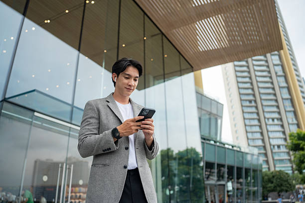 istock Confident young businessman using smartphone outdoors 2216086184