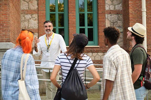 istock Tour guide explaining to tourists in front of a building 2216088136
