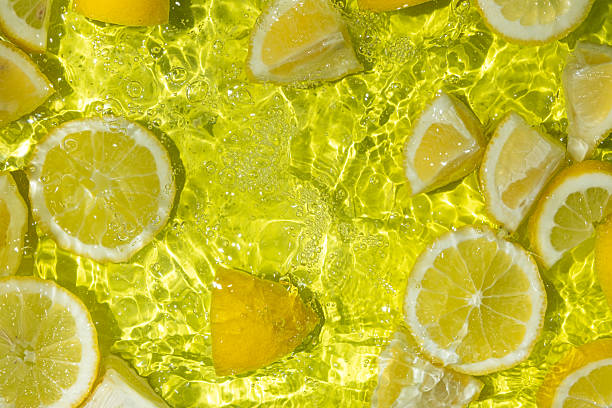 istock Vibrant yellow lemon pieces floating in motion water 2216090785