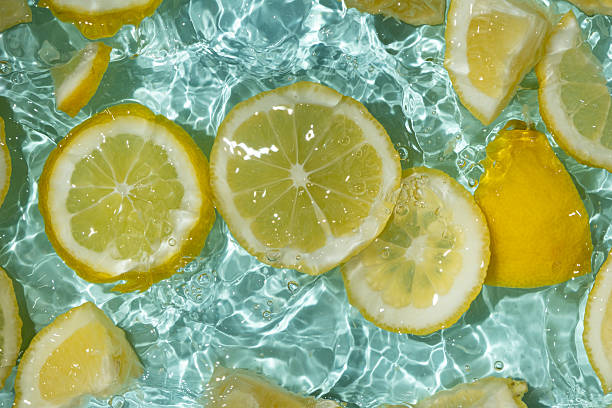 istock Refreshing turquoise citrus background with floating yellow lemon pieces 2216090791