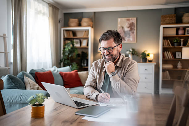 istock Mid adult man working remotely in cozy home office 2216091175