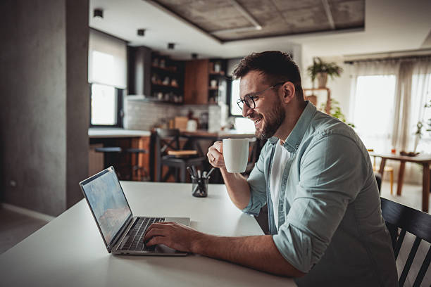 istock Freelancer working from home drinking coffee and typing on laptop 2216091829