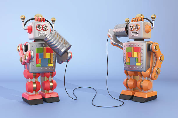 istock Two toy robots communicating with tin cans in a playful setting 2216092942