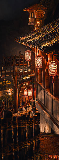 istock Scenic illuminated pathway winding through Wangxian Valley Town at night, blending natural rock formations and traditional Chinese architecture in a peaceful mountain setting. 2216094340