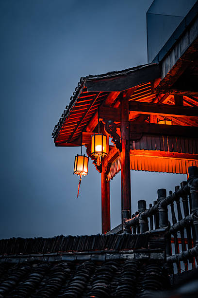istock Traditional Chinese lanterns glowing under wooden eaves at dusk, showcasing classic architecture and serene atmosphere in Wangxian Valley Town. 2216094354
