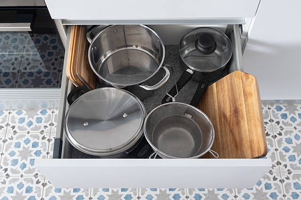 istock Organized kitchen drawer with stainless steel cookware and cutting board, top view 2216094864