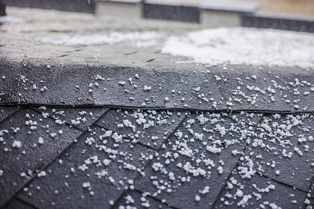 istock Small hailstones scattered on a dark shingled roof during a rainstorm. 2216095138