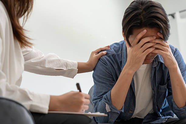 man with mental health problems is consulting. psychiatrist is recording the patient's condition for treatment. encouragement, love and family problem, bipolar , depression patient, protect suicide - うつ病 治る ストックフォトと画像