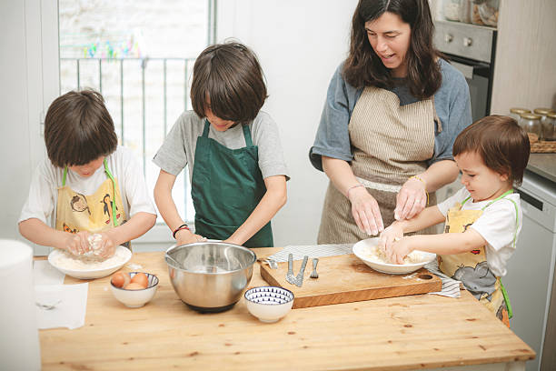 istock Mother and three children preparing cookie dough together 2216103648