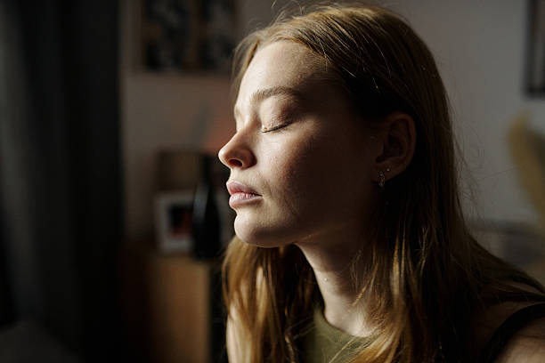 istock Contemplating Woman With Eyes Closed in Soft Light 2216111428