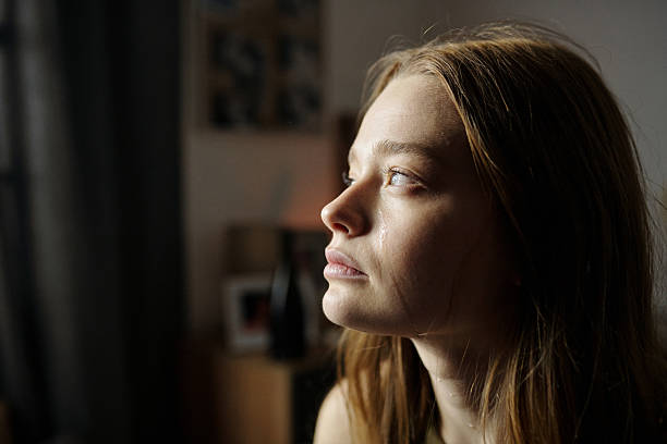 istock Woman Contemplating Next to Window and Looking Thoughtful 2216111430