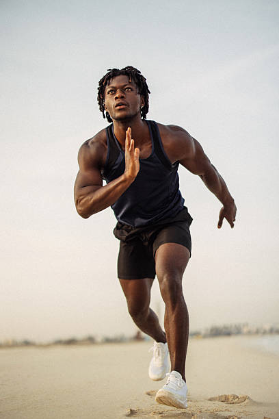 Athletic man running on a sandy trail during a morning workout