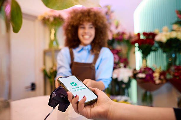 istock Customer paying with NFC technology on smartphone in flower shop 2216115690