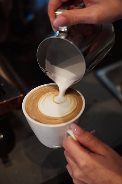istock Barista pouring milk into coffee cup creating latte art 2216115899