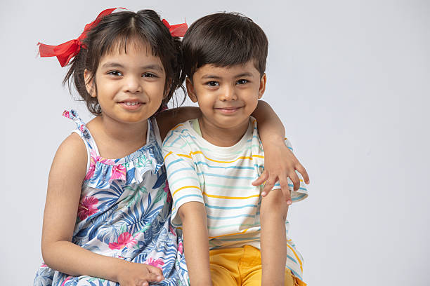 istock Sister and brother against white background 2216116654