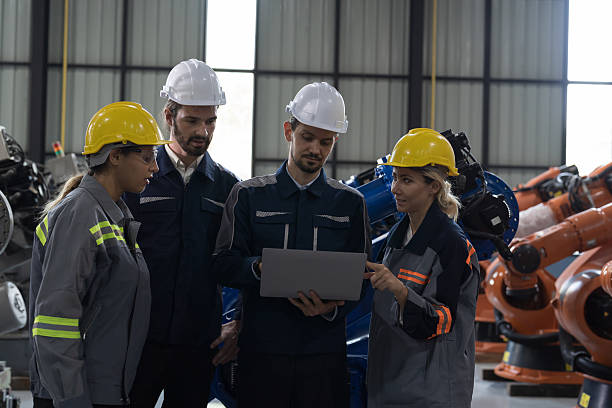 istock Engineer team, Automatic robotics arms in storage warehouse. Engineer team disccussing for installation, testing or setting robotics arms 2216116770