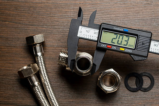 Measuring the diameter of plumbing adapters with an electronic digital caliper, closeup, top view. Plumbing repair concept Measuring the diameter of plumbing adapters with an electronic digital caliper, close up, top view. Plumbing repair concept micrometer screw gauge stock pictures, royalty-free photos & images