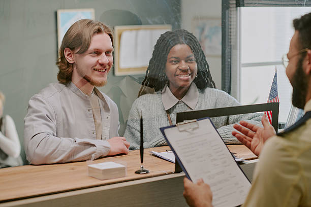 istock Smiling Couple Interacting with Male Visa Officer 2216120837