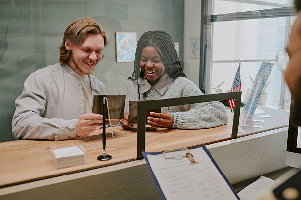 Smiling Couple Filling Out Forms in Public Office
