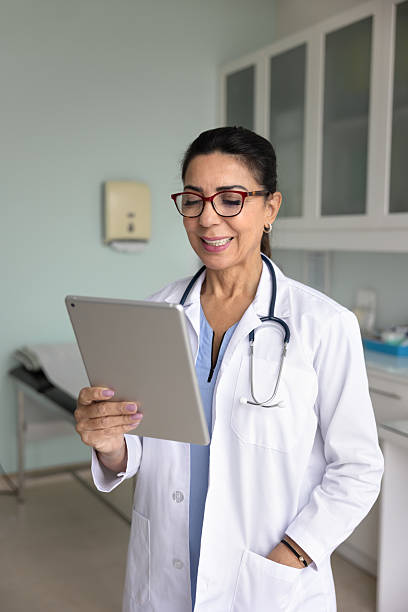 istock Positive experienced middle aged doctor woman using tablet for communication 2216121707