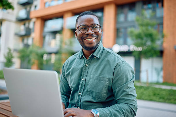 istock Smiling businessman working on laptop outdoors in urban setting 2216125335