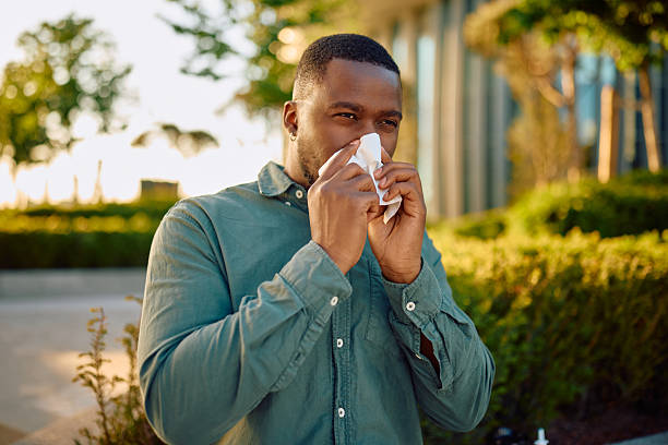 istock Businessman blowing his nose with a tissue outdoor 2216125579