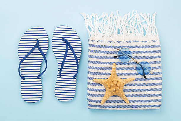 istock Beach towel with summer accessories on color background, top view 2216126975