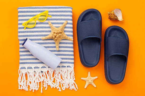 istock Beach towel with summer accessories on color background, top view 2216126977