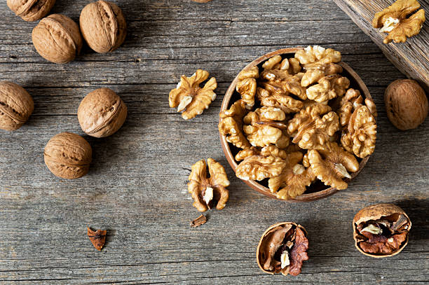 istock Ripe and fresh walnut kernels in bowl without shell on rustic table, healthy nut food for brain 2216127155