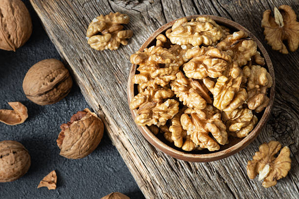 istock Ripe and fresh walnut kernels in bowl without shell on rustic table, healthy nut food for brain 2216127201