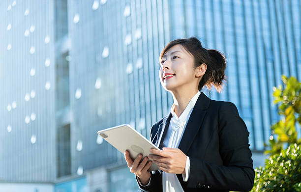 istock Businesswoman using digital tablet outside the office building 2216128135