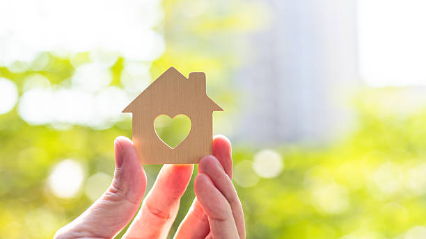 istock Human hand holding model house with a heart shape 2216129226