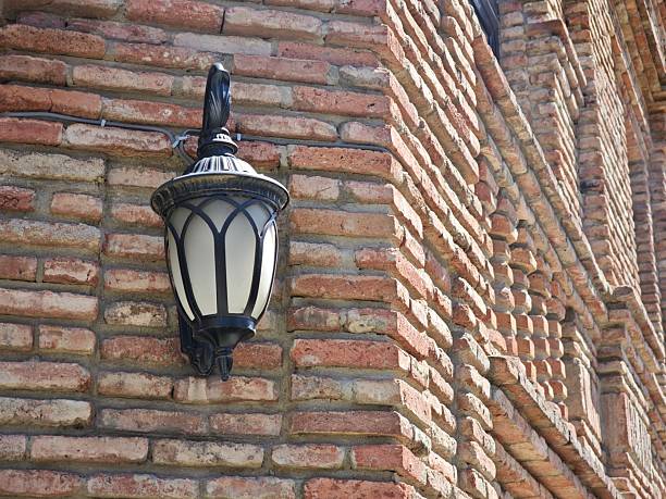 istock Ornate street lamp illuminating a brick wall 2216129786