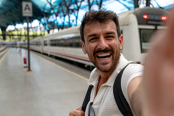 istock Happy tourist taking selfie at train station 2216131150