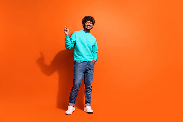 istock Full length portrait of nice handsome man indicate finger empty space novelty isolated on orange color background 2216133162