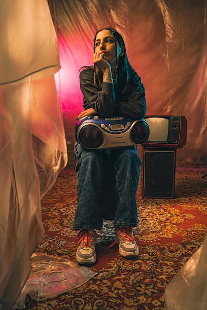 istock Contemplative Woman Posing with Retro Electronics and Colorful Background 2216135906