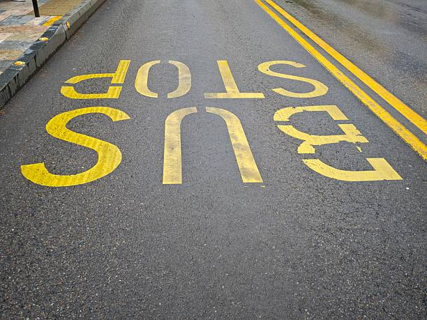 istock Bus stop sign painted on asphalt showing public transportation infrastructure 2216136233