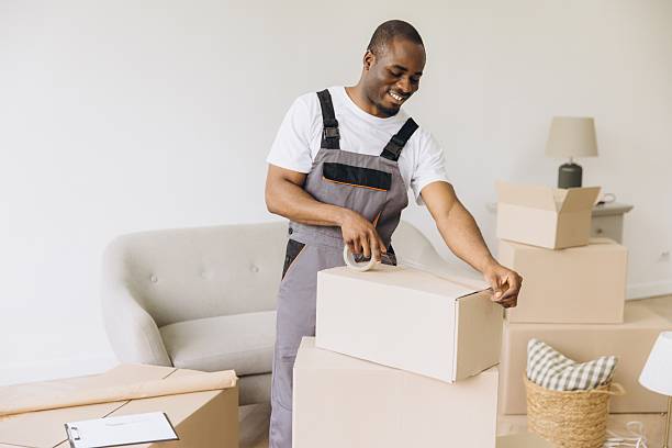 istock African American mover packing cardboard boxes for house move 2216139277