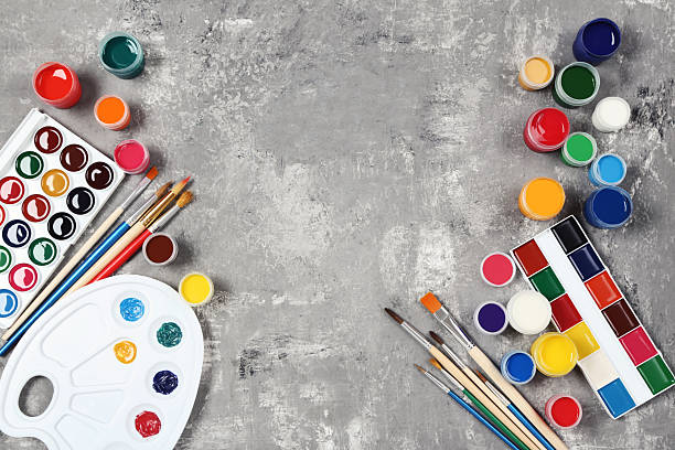 istock Colorful gouache paints and brushes on grey wooden table 2216139865