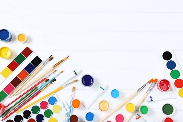 istock Colorful gouache paints and brushes on white wooden table 2216139910