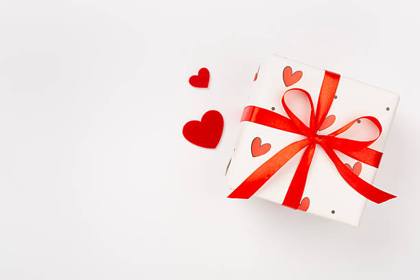 istock Festive gift boxes with red hearts on color background, top view 2216140179
