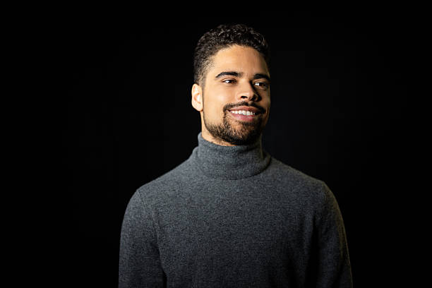 istock Hispanic man looking away smiling against a dark background 2216143708