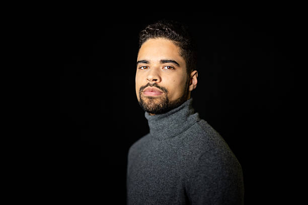 istock Handsome man in gray turtleneck t-shirt against black backdrop 2216143848