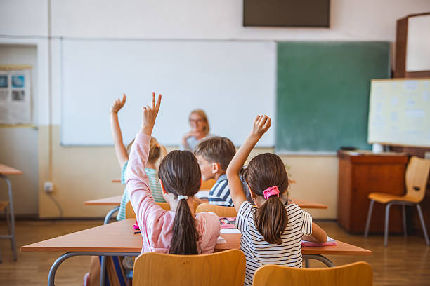 istock school kids raise hand to answer a question during a lesson 2216145558