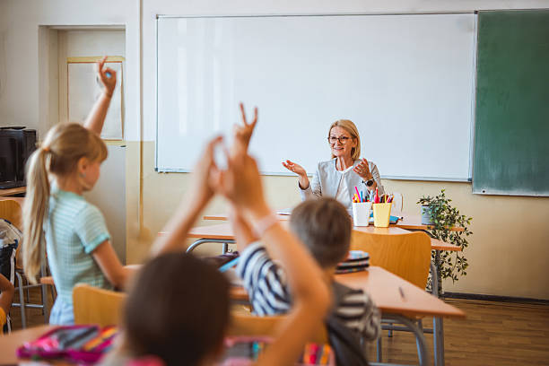 istock school kids raise hand to answer a question during a lesson 2216145646