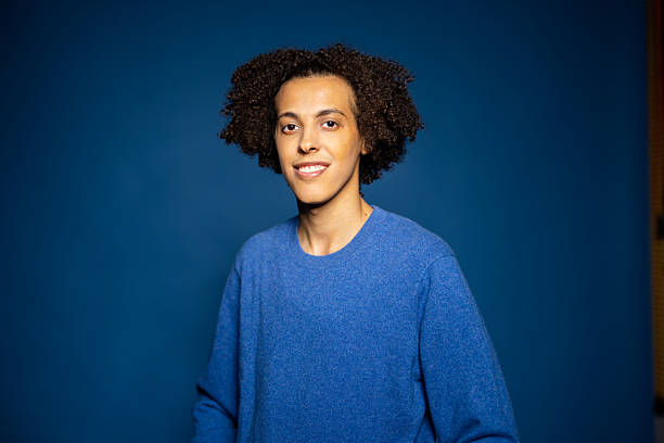 istock Middle Eastern man with curly hair smiling against blue backdrop 2216146427