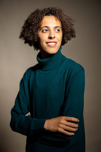 istock Man wearing green jumper looking away smiling in studio 2216146441