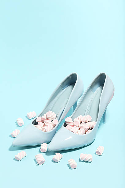 High heeled shoes with marshmallows on blue background. Minimalism concept