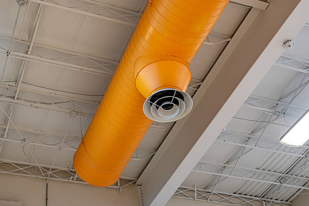 istock Interior building HVAC, mechanical systems, orange duct, ventilation pipes, with white diffuser, hanging from the ceiling of a large open space. 2216146767