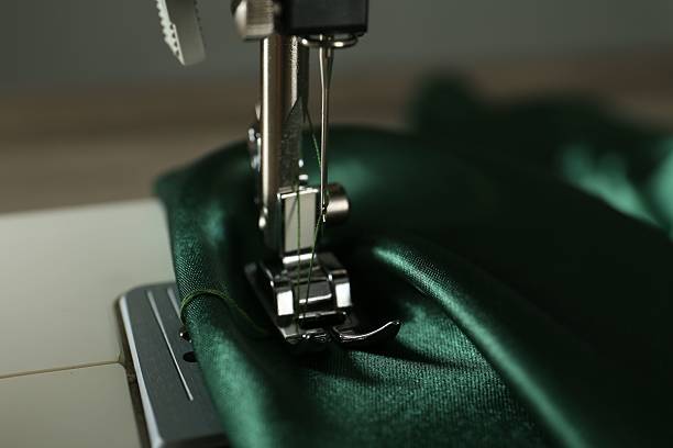 istock Sewing machine with green fabric on light background, closeup 2216152488